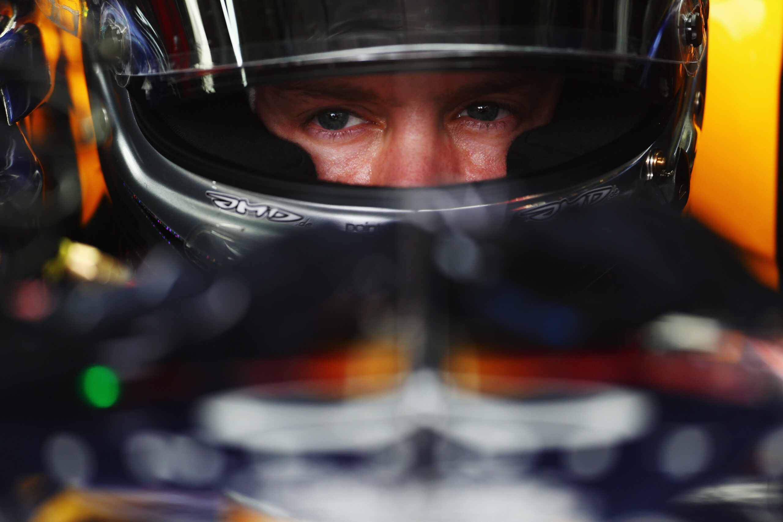 A close up looking into the eyes of Sebastian Vettel while in his Red Bull car 