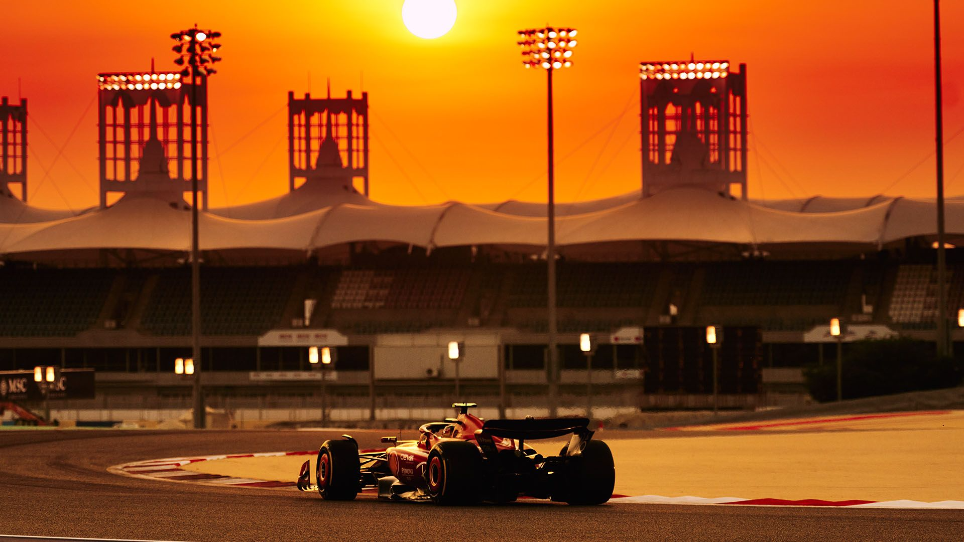 A Ferrari being driven at Bahrain in the sunset