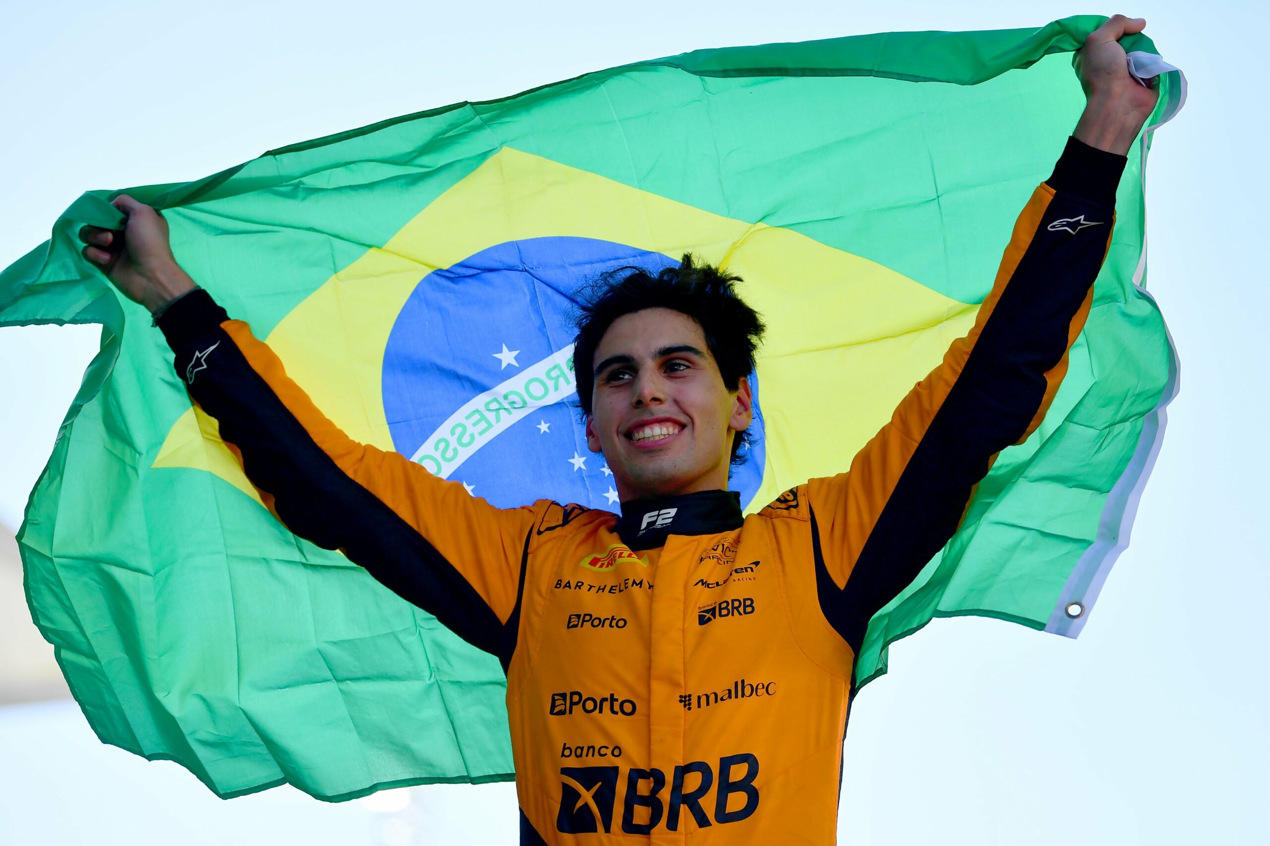 Gabriel Bortoleto raising the Brazilian flag after winning the 2024 Formula 2 Championship.