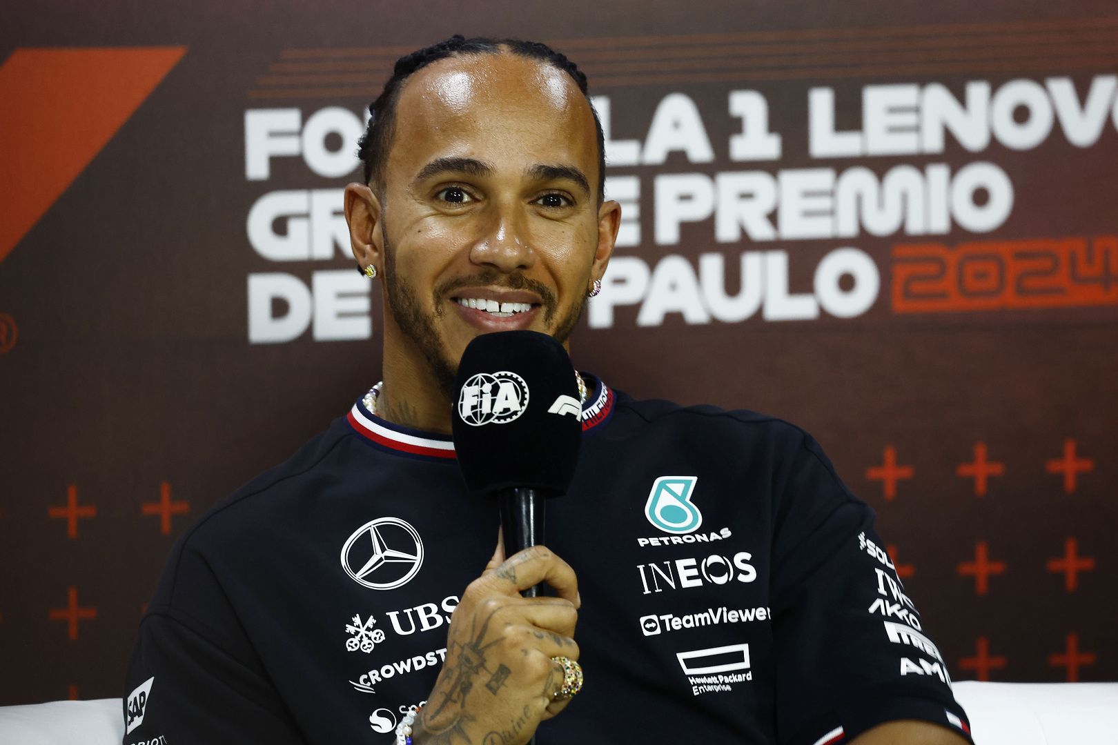 A racing driver speaking to a group of journalists.