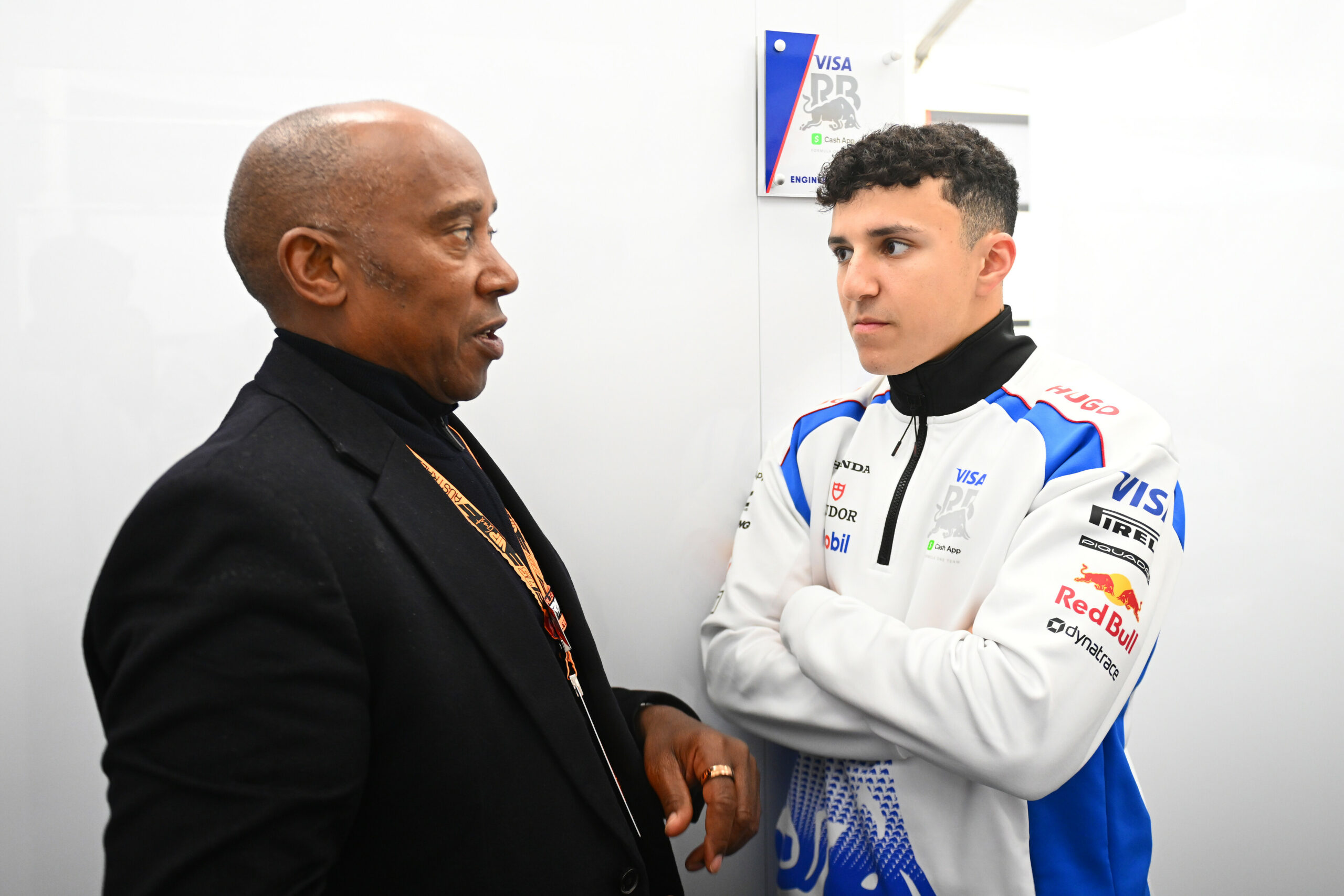 MELBOURNE, AUSTRALIA - MARCH 16: Anthony Hamilton with Isack Hadjar of France and Visa Cash App Racing Bulls in the garage during the F1 Grand Prix of Australia at Albert Park Grand Prix Circuit on March 16, 2025 in Melbourne, Australia